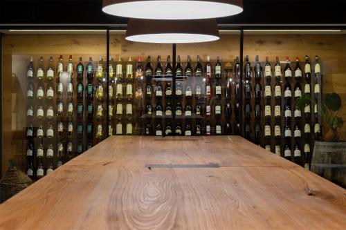 a wall of wine bottles behind a wooden table at Hotel San Teodoro in San Teodoro