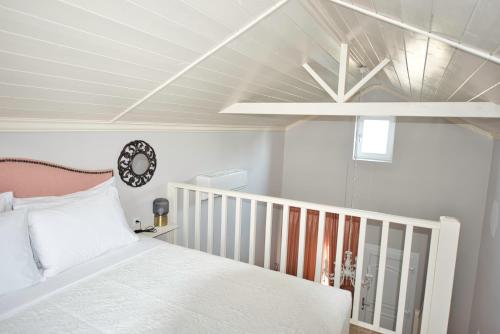 um quarto com uma cama branca e um tecto em Nafsika Suites em Nea Moudania