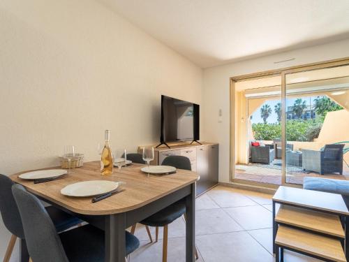 une salle à manger avec une table avec des chaises et une télévision dans l'établissement Apartment Les Regates-5 by Interhome, à Hyères