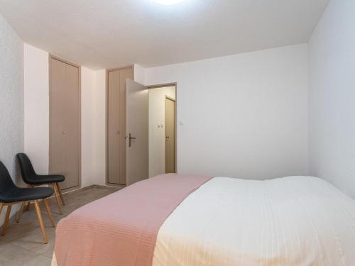 - une chambre blanche avec un lit et deux chaises dans l'établissement Apartment Les Regates-5 by Interhome, à Hyères