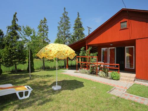 ein rotes Haus mit gelbem Regenschirm im Hof in der Unterkunft Chalet Rosso by Interhome in Balatonmáriafürdő