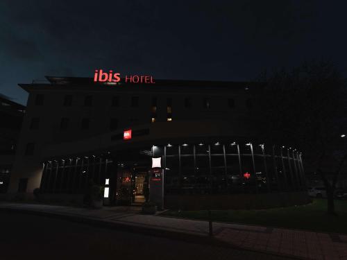 a building with a sign on top of it at night at Ibis Valladolid in Valladolid