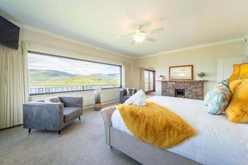 a bedroom with a large bed and a fireplace at Dingle Bay Nest in Dingle