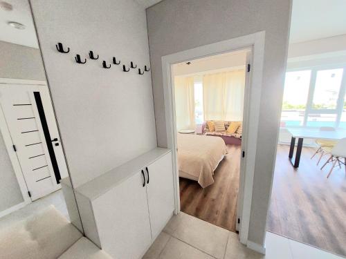 a room with a bedroom with a bed and a table at Уютные апартаменты в новострое на Ботанике in Chişinău
