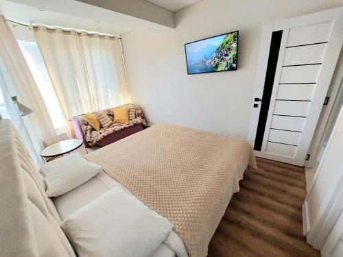 a bedroom with a bed and a tv on the wall at Уютные апартаменты в новострое на Ботанике in Chişinău