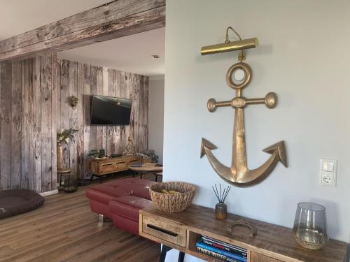 a living room with a red couch and an anchor on the wall at Zu Fuß zum Strand - familienfreundlich zwischen Wismar und Boltenhagen Wallbox am Haus! in Beckerwitz