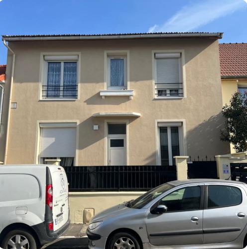 deux voitures garées devant une maison dans l'établissement Cosy studio aux portes de Paris, à Bagneux