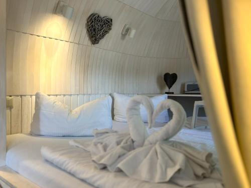 dwa białe łabędzie siedzące na łóżku w obiekcie Iglu Camp Templin w mieście Templin