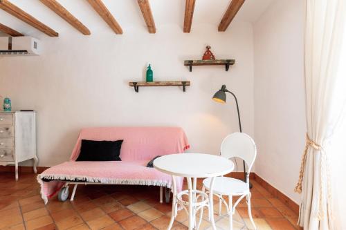 a room with a pink couch and a table at Origens I - Precióso apartamento in Perelló