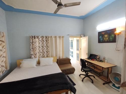 a bedroom with a bed and a desk and a table at Bakri Chhap Stays The Senti Niketan in Dehradun