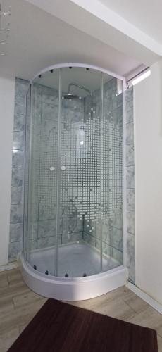a shower in a room with a glass wall at Charm Junior Rooms in Eforie Nord