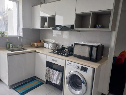 a kitchen with a washing machine and a microwave at Ivy Apartment- Lotus in Mount Lavinia