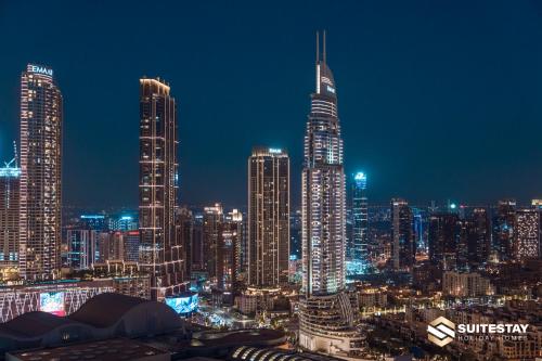 a night view of a city with tall buildings at Fashion avenue Dubai Mall -The Residence in Dubai