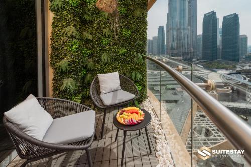 a balcony with two chairs and a bowl of fruit on a table at Fashion avenue Dubai Mall -The Residence in Dubai