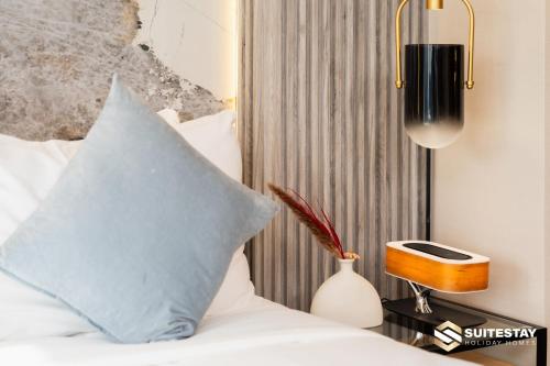 a bedroom with a bed with a blue pillow and a lamp at Fashion avenue Dubai Mall -The Residence in Dubai