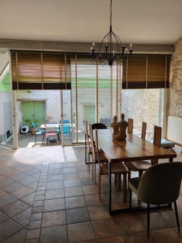 une salle à manger avec une table et des chaises en bois dans l'établissement Grand appartement en Minervois, à Villeneuve-Minervois