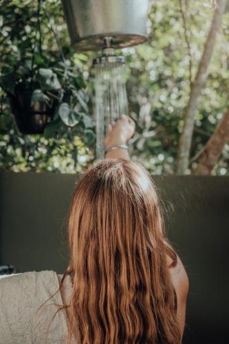 a woman with long hair reaching up to a bird at Firefly Falls in Plettenberg Bay
