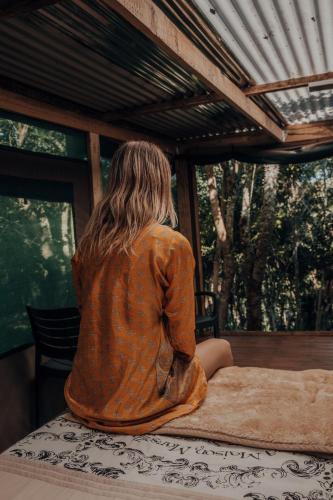a person sitting on a table looking out of a window at Firefly Falls in Plettenberg Bay