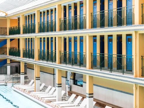 - une vue extérieure sur un bâtiment avec des chaises blanches dans l'établissement Molitor Hôtel & Spa Paris - MGallery Collection, à Paris
