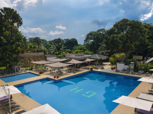 - Vistas a la piscina de un complejo con sombrillas en Pullman Kinshasa Grand Hotel, en Kinshasa