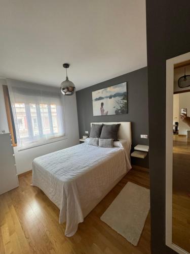 a bedroom with a white bed in a room at Duplex Moaña Centro in Moaña