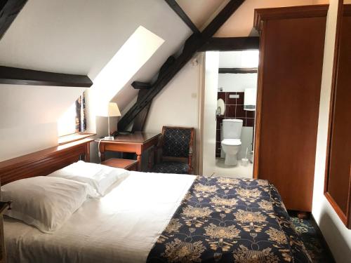 une chambre avec un lit et un bureau et une salle de bain dans l'établissement Logis Hôtel & Restaurant - Le Château Des Tourelles 3 étoiles, à Le Wast
