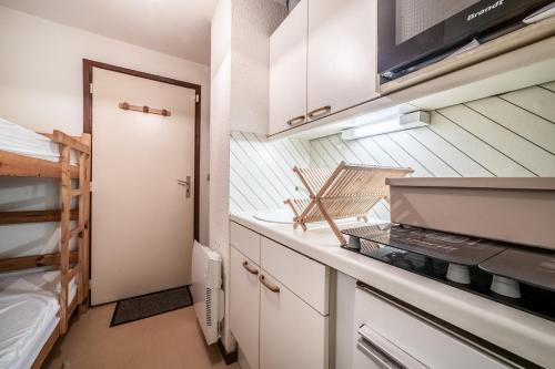 Il comprend une petite cuisine équipée d'une cuisinière et de lits superposés. dans l'établissement Le Cozy Tétras, à Morillon