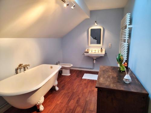 une salle de bain avec une baignoire, des toilettes et un lavabo dans l'établissement Château de Beauménil, paisible et familial, à Beauménil