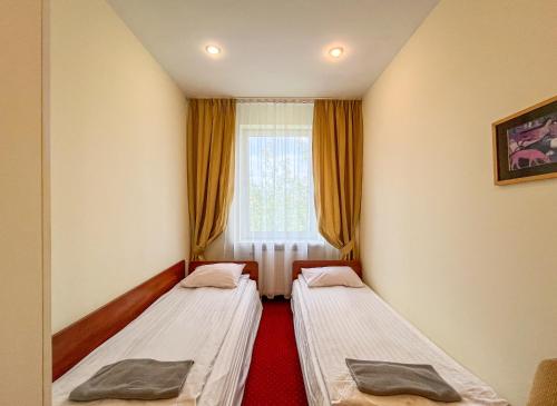 two beds in a room with a window at Fry House in Warsaw