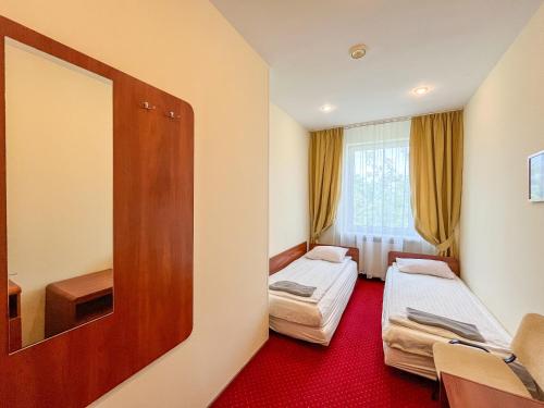 a hotel room with two beds and a mirror at Fry House in Warsaw