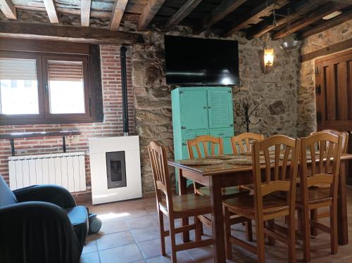 a dining room with a table and chairs and a television at CASA ABUELo CAÑI in Arenas de San Pedro