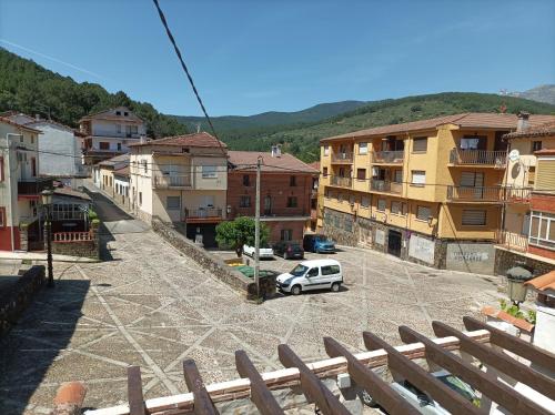 a white car parked in a parking lot next to buildings at CASA ABUELo CAÑI in Arenas de San Pedro