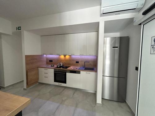 a kitchen with white cabinets and a stainless steel refrigerator at Hostelum in Umag