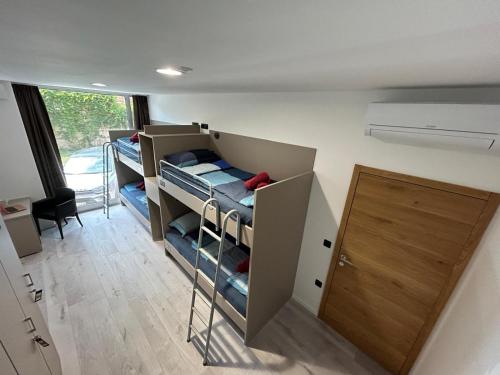 a room with three bunk beds and a door at Hostelum in Umag