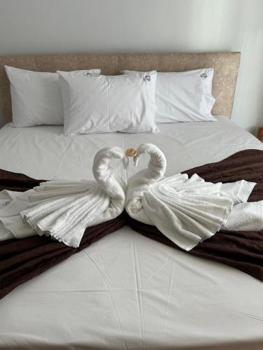 two swans making a heart on a bed at Dionisos Roses in Paralia Dionysiou