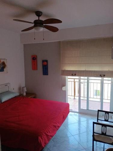 a bedroom with a red bed and a ceiling fan at ADRIJUL in Moraira