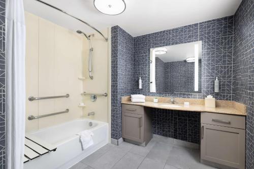 y baño con bañera, lavamanos y bañera. en Homewood Suites by Hilton Sacramento/Roseville, en Roseville