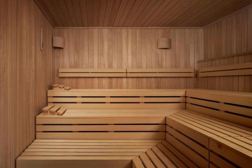 uma sauna com painéis de madeira e bancos em NH Collection Frankfurt Spin Tower em Frankfurt am Main