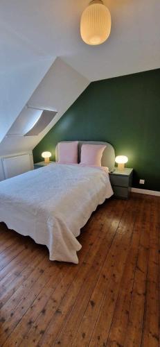 une chambre avec un grand lit avec un mur végétal dans l'établissement La Verrière, à Cherbourg en Cotentin