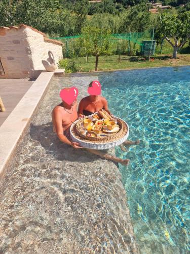 trois hommes assis dans une piscine avec un plateau de nourriture dans l'établissement Margaux, au Plan-de-la-Tour
