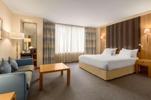 pokój hotelowy z łóżkiem i kanapą w obiekcie NH Gent Belfort w Gandawie