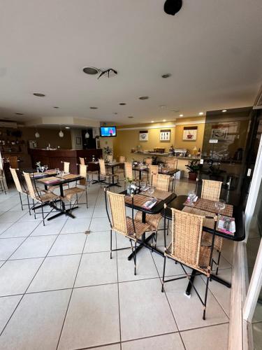 a restaurant with tables and chairs in a room at Plaza Flat in Ribeirão Preto