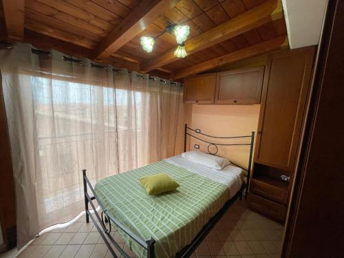 a bedroom with a bed in a room with a window at L’Attico in Centro da Salvatore in Fondi