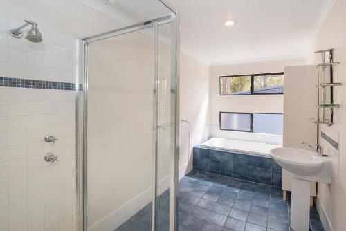 a bathroom with a shower and a sink and a tub at Cape Illawarra Holiday House Margaret River in Margaret River Town