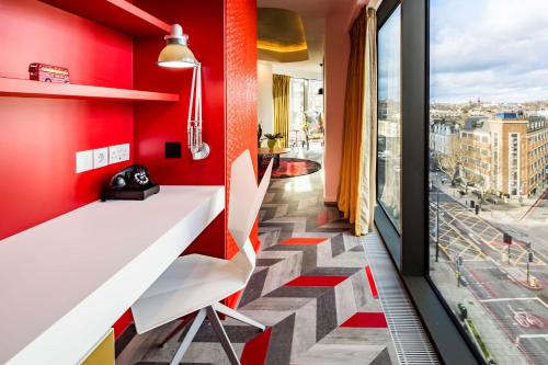 a stairway with a white desk and a red wall at nhow London in London