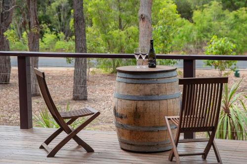 Un barril con dos copas de vino y dos sillas. en Cape Illawarra Holiday House Margaret River, en Margaret River Town