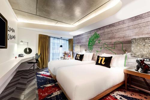 ein Hotelzimmer mit 2 Betten und einer Ziegelwand in der Unterkunft nhow London in London