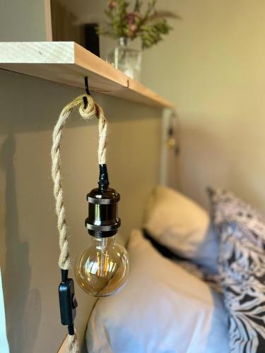 une lumière suspendue à un mur près d'un lit dans l'établissement Les 2 anes, à Casaglione