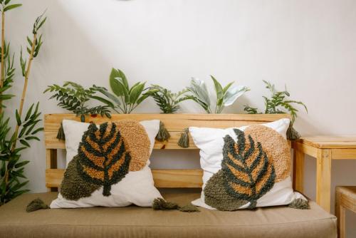 two pillows on a bench with plants in the background at Pallet Homes - Petalsville in Iloilo City