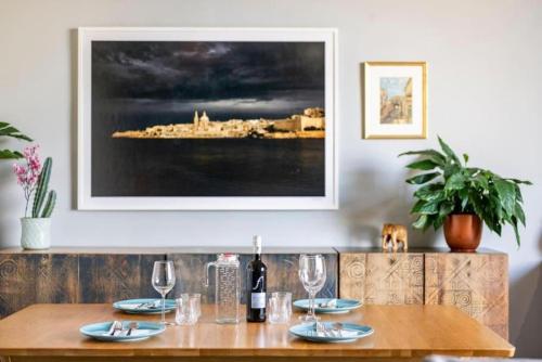a table with wine glasses and a picture on the wall at Seabreeze Retreat with terrace - St Julians in St Julian's